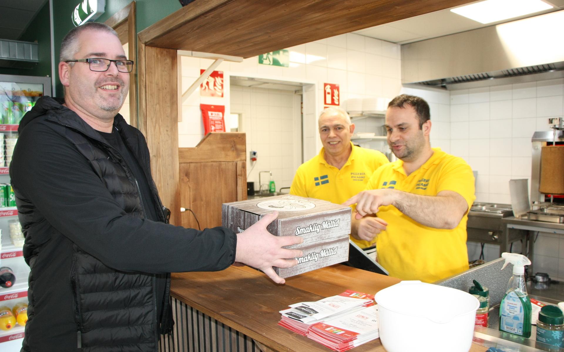 Stamkunden Lennart Pieper köper pizzor av Sebahattin Akdeniz och Nurullah Yenigun.